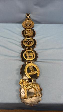 (6) PIECES OF HORSE BRASS ON LEATHER HANGER